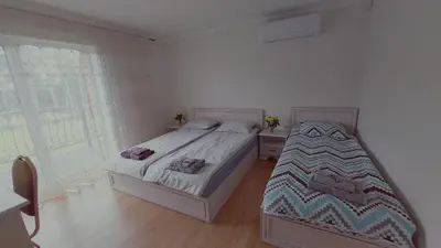 a bedroom with two beds and a window at Marių įlanka in Marijampolė