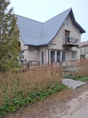 a house with a metal roof and a fence at Lat4Rest in Prienai