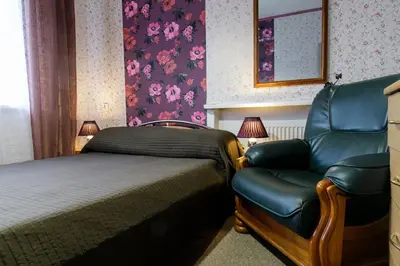 a bedroom with a bed and a chair next to a bed at Lat4Rest in Prienai