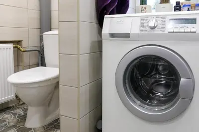 a bathroom with a washing machine and a toilet at Lat4Rest in Prienai