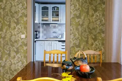 a kitchen with a table with a bowl of fruit on it at Lat4Rest in Prienai