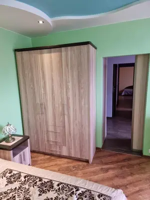 a bedroom with a large wooden closet and a mirror at Apartment Maya in Visaginas