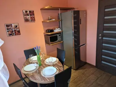 a dining room with a table and chairs and a microwave at Apartment Maya in Visaginas