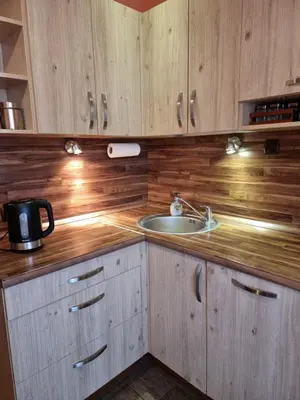a kitchen with wooden cabinets and a sink at Apartment Maya in Visaginas