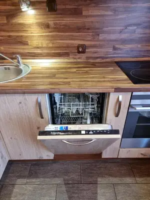an open dishwasher in a kitchen with a sink at Apartment Maya in Visaginas
