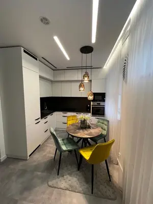 a kitchen with a table and chairs in a room at ADIS Apartments in Druskininkai