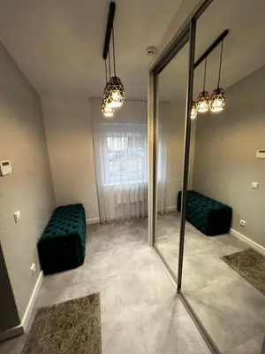 a room with a mirror and a green couch at ADIS Apartments in Druskininkai