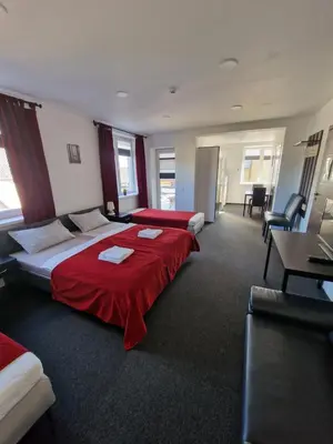 a hotel room with two beds with red sheets at KALIDA Rooms for rent in Raseiniai