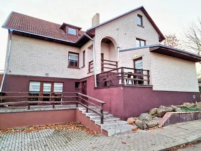 a large house with a staircase in front of it at KALIDA Rooms for rent in Raseiniai