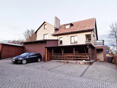 a black car parked in front of a house at KALIDA Rooms for rent in Raseiniai