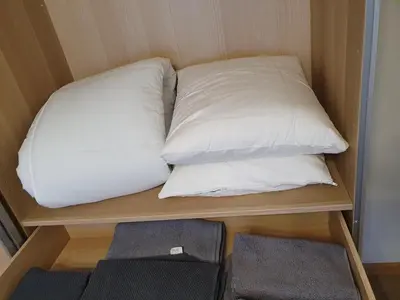 a bed with two pillows sitting on a shelf at Dainai 1-Bedroom apartament. in Šiauliai