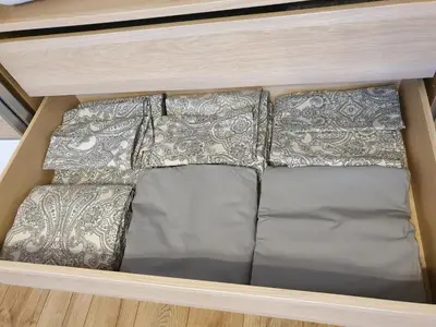 a shelf with three pillows in a drawer at Dainai 1-Bedroom apartament. in Šiauliai