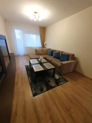 a living room with a couch and a table at Dainai 1-Bedroom apartament. in Šiauliai