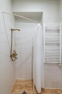 a shower with a white shower curtain in a bathroom at Archcathedral apartment by Polo Apartments in Kaunas