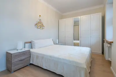 a bedroom with a large white bed and a dresser at Archcathedral apartment by Polo Apartments in Kaunas