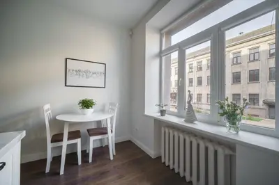 a dining room with a table and a window at Nica Apartment in Šiauliai
