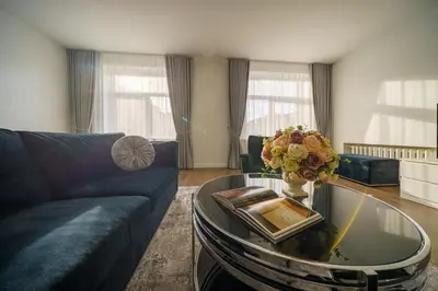 a living room with a couch and a glass table at Nica Apartment in Šiauliai