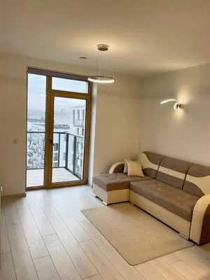 a living room with a couch and a large window at Central apartment in Vilnius