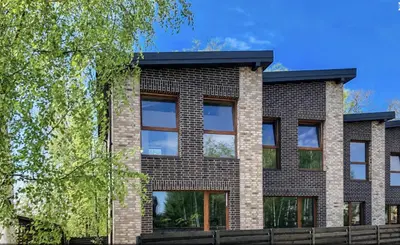 a brick building with a black roof at SPA TOWN house I in Druskininkai