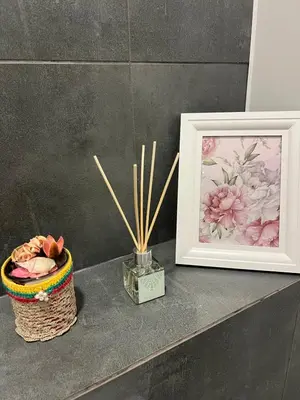 a table with a picture and a basket with bamboo sticks at SPA TOWN house I in Druskininkai