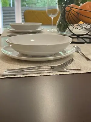 a table with two white plates and silverware on it at SPA TOWN house I in Druskininkai