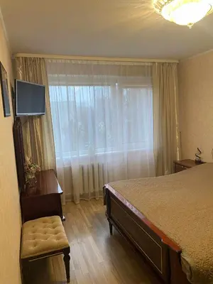 a bedroom with a large bed and a window at Apartamentai šalia parko in Šiauliai