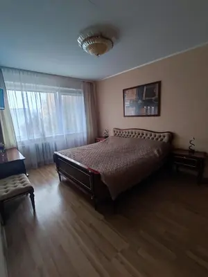 a bedroom with a large bed and a window at Apartamentai šalia parko in Šiauliai