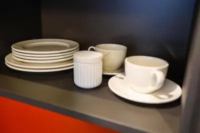 a shelf with plates and coffee cups on it at Studio 501 in Kaunas