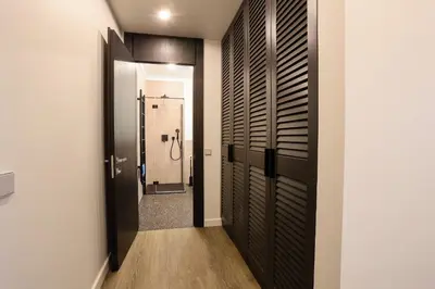a bathroom with a walk in closet with black doors at Studio 501 in Kaunas