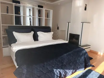 a bedroom with a large bed with a black blanket at Skaistakalnio apartamentai in Panevėžys