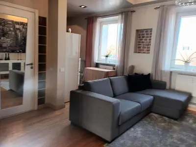 a living room with a couch and a kitchen at Skaistakalnio apartamentai in Panevėžys