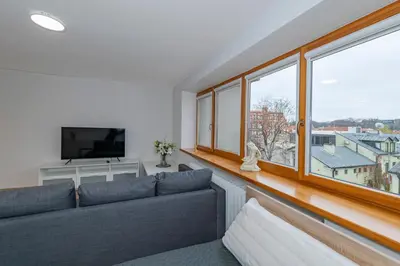 a living room with a couch and a large window at Archcathedral studio apartment by Polo Apartments in Kaunas