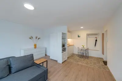 a living room with a couch and a kitchen at Archcathedral studio apartment by Polo Apartments in Kaunas