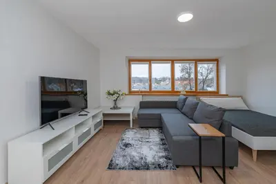a living room with a couch and a tv at Archcathedral studio apartment by Polo Apartments in Kaunas