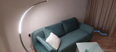 a living room with a green couch with a pillow at Pakeliui in Kaunas
