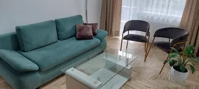 a living room with a green couch and two chairs at Pakeliui in Kaunas