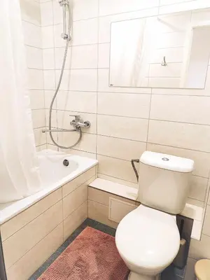 a white bathroom with a toilet and a bath tub at Pakeliui in Kaunas