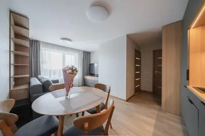 a kitchen and a living room with a table and chairs at Gynėjų Self Check-in Apartments - Lollo Stay in Vilnius
