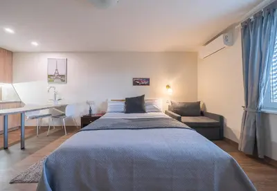 a bedroom with a bed and a table and a desk at Gynėjų Self Check-in Apartments - Lollo Stay in Vilnius