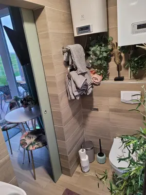 a small room with a wall with wooden tiles at Vaitų Riešutynė - Small shipping container house in Antanava