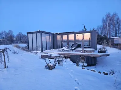 a cabin in the snow with a table and chairs at Vaitų Riešutynė - Small shipping container house in Antanava