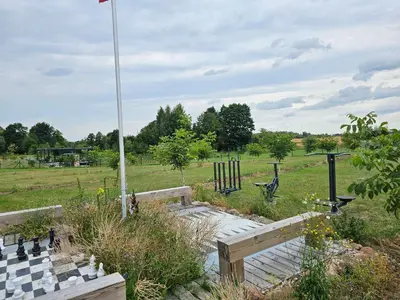 a chess board and a flag in a field at Vaitų Riešutynė - Small shipping container house in Antanava