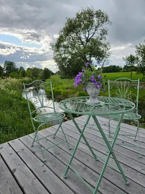 a table and two chairs with a vase with flowers on it at Vaitų Riešutynė - Small shipping container house in Antanava