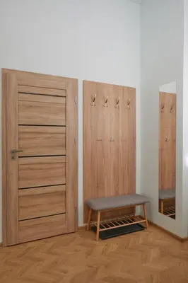 a room with wooden doors and a bench and a mirror at Modern Flat by Lukiskiu square in Vilnius