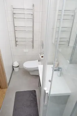 a white bathroom with a toilet and a sink at Modern Flat by Lukiskiu square in Vilnius