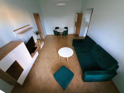 a living room with a green couch and a table at Modern Flat by Lukiskiu square in Vilnius