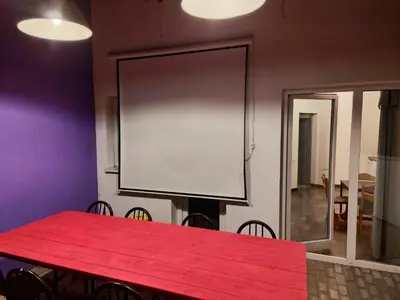 a red table in a room with a large screen at Comfort Mile Apartments in Vilnius