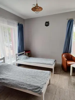a bedroom with two twin beds and a chair at Comfort Mile Apartments in Vilnius