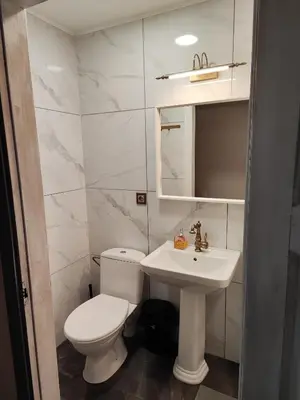 a white bathroom with a toilet and a sink at Comfort Mile Apartments in Vilnius