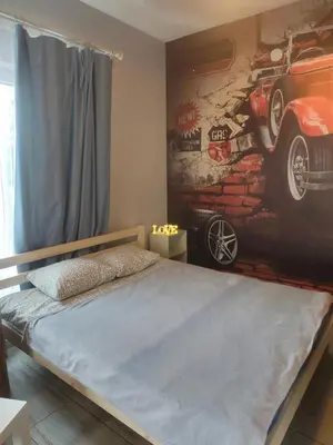 a bedroom with a painting of a car on the wall at Comfort Mile Apartments in Vilnius